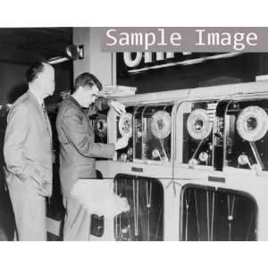  1959 One man looks on as another man prepares Univac 